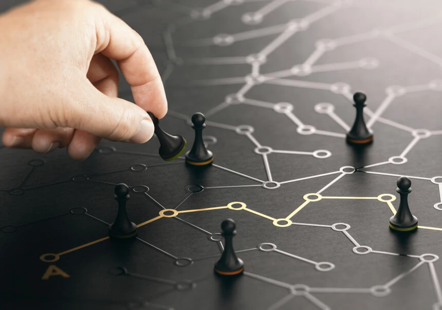 Hand placing a chess pawn on a network of connected nodes — illustration of omnichannel strategy and customer touchpoints