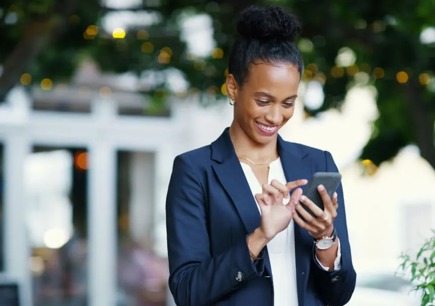 A businesswoman smiling while receiving a Business Messaging notification on her smartphone. A manager reading an urgent automated SMS alert and instant messaging update.