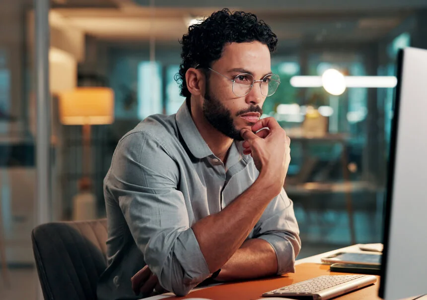 A focused marketing specialist analyzing an effective landing page for an ad campaign on a computer screen. A UX designer in an office planning conversion optimization elements.